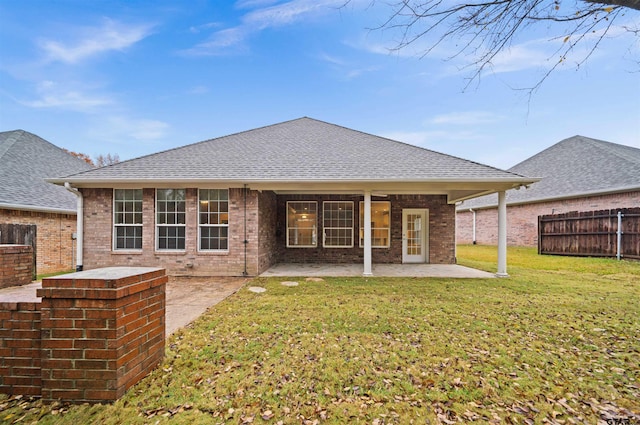 rear view of property featuring a yard and a patio area