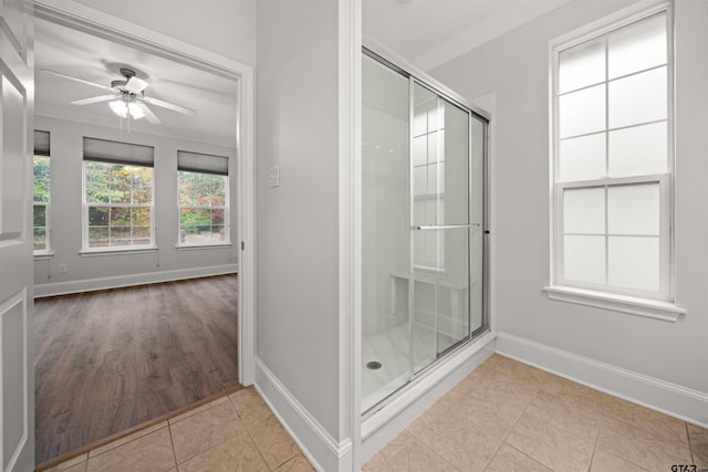 bathroom with hardwood / wood-style floors, ceiling fan, crown molding, and walk in shower