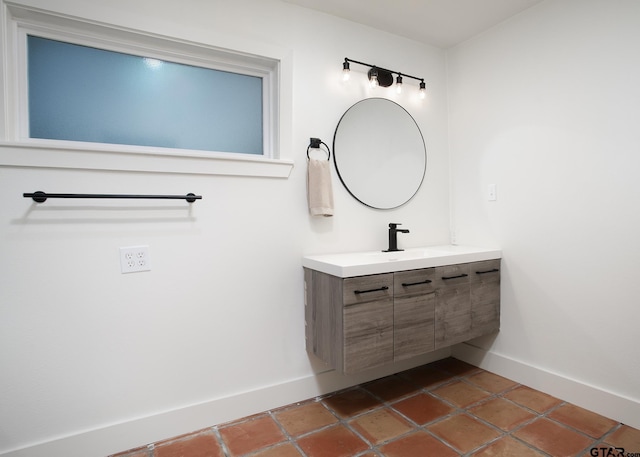 bathroom with baseboards, tile patterned floors, and vanity
