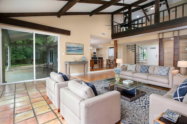 living area with stairway, beam ceiling, visible vents, a notable chandelier, and a high ceiling