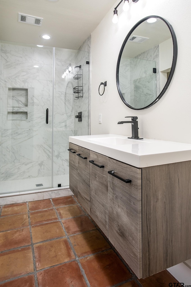 full bathroom featuring a marble finish shower, visible vents, and vanity