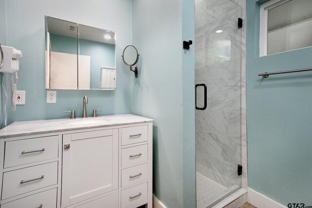 bathroom with a shower stall and vanity