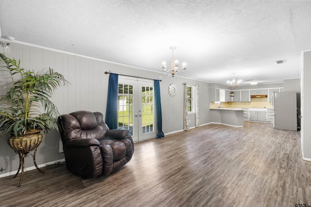 living room featuring visible vents, a notable chandelier, a textured ceiling, wood finished floors, and french doors
