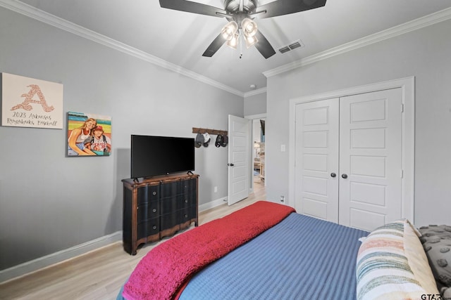 bedroom featuring ornamental molding, light hardwood / wood-style flooring, ceiling fan, and a closet