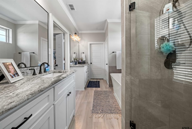 bathroom with hardwood / wood-style floors, vanity, separate shower and tub, and ornamental molding