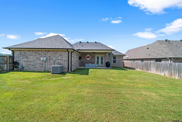 rear view of property featuring central AC, a yard, and a patio area