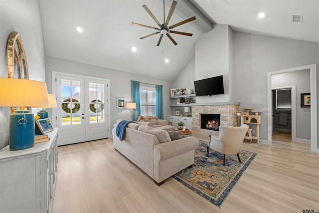 living room with french doors, light hardwood / wood-style flooring, a fireplace, and high vaulted ceiling