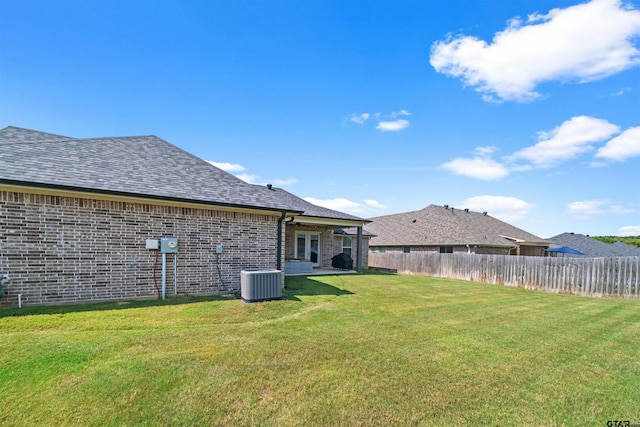 view of yard with central AC unit and a patio area