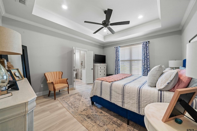 bedroom featuring light hardwood / wood-style floors, ceiling fan, ornamental molding, and a tray ceiling