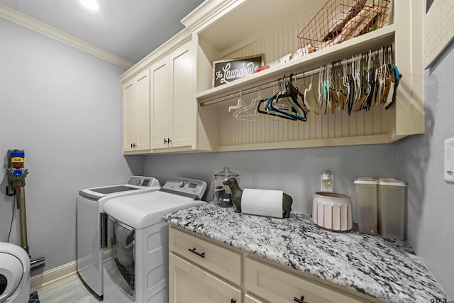 laundry room featuring separate washer and dryer, light hardwood / wood-style flooring, cabinets, and crown molding