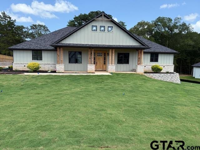 14533 Woodland Creek Dr, Tyler, TX 75706 - view of front of house with board and batten siding, a porch, a front lawn, and a shingled roof