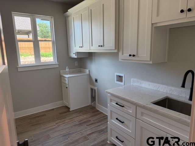 14533 Woodland Creek Dr, Tyler, TX 75706 - laundry area with cabinet space, hookup for an electric dryer, washer hookup, and wood finished floors