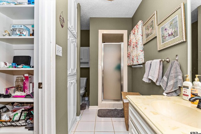 552 W State Highway 7, Crockett, TX 75835 - bathroom featuring a shower stall, tile patterned floors, vanity, toilet, and a textured ceiling