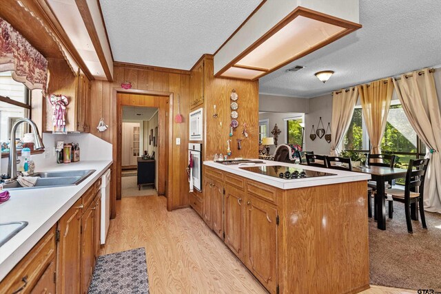 552 W State Highway 7, Crockett, TX 75835 - kitchen featuring a textured ceiling, white appliances, a sink, light countertops, and brown cabinetry