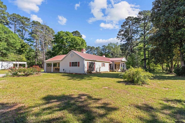 552 W State Highway 7, Crockett, TX 75835 - rear view of property with a chimney, a lawn, metal roof, and view of wooded area