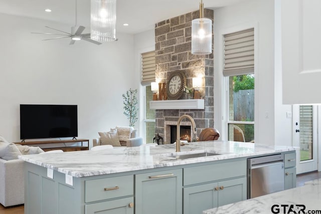 4188 Palo Pinto Creek Cir, Tyler, TX 75703 - kitchen with open floor plan, light stone countertops, a fireplace, a ceiling fan, and decorative light fixtures