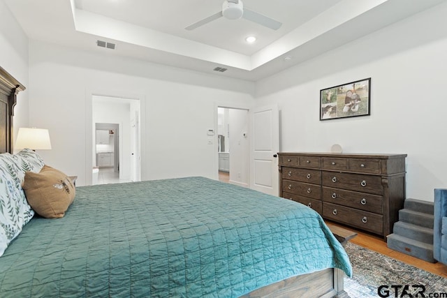 4188 Palo Pinto Creek Cir, Tyler, TX 75703 - bedroom with a raised ceiling, wood finished floors, connected bathroom, recessed lighting, and a ceiling fan