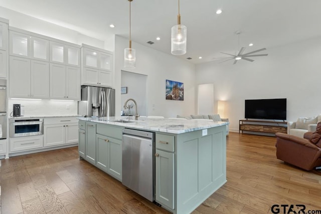 4188 Palo Pinto Creek Cir, Tyler, TX 75703 - kitchen featuring light wood finished floors, open floor plan, white cabinetry, a ceiling fan, and appliances with stainless steel finishes