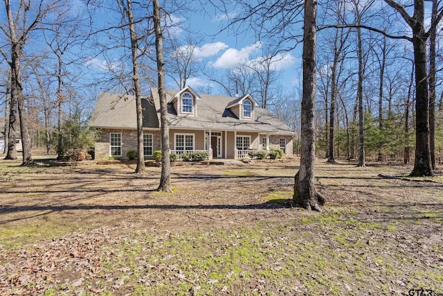 cape cod-style house with covered porch