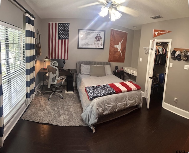 bedroom featuring hardwood / wood-style floors, a spacious closet, ceiling fan, and a closet