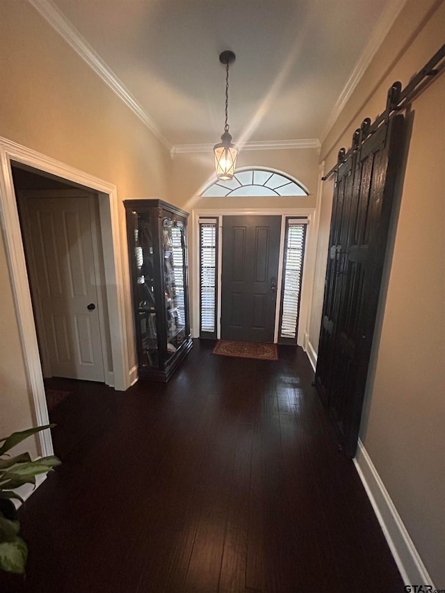 entryway featuring ornamental molding, a barn door, and dark hardwood / wood-style floors