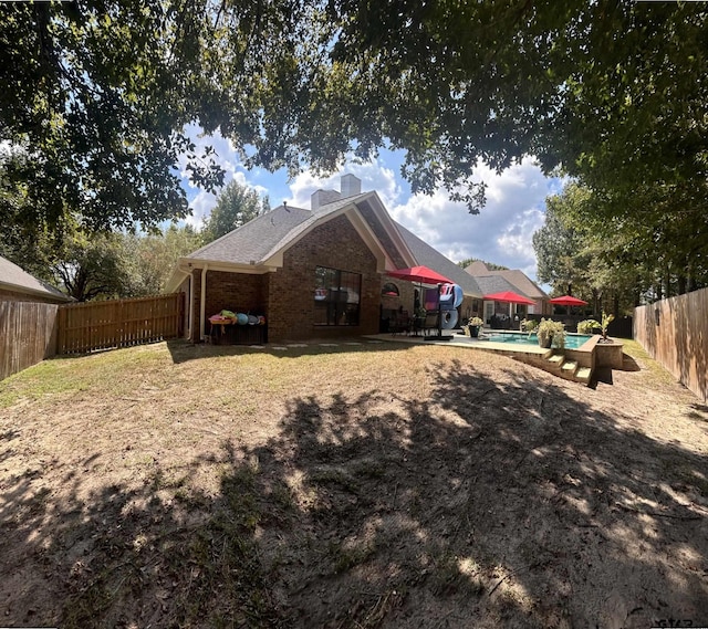 back of house featuring a fenced in pool and a patio