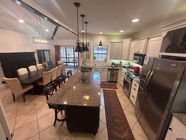 kitchen with pendant lighting, stainless steel appliances, sink, and a kitchen island