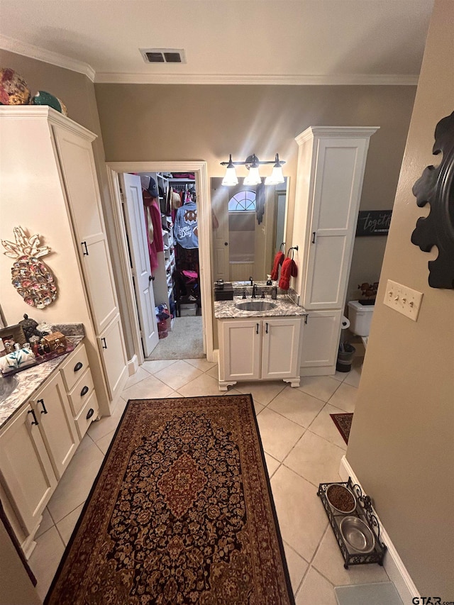 bathroom with tile patterned flooring, vanity, and crown molding