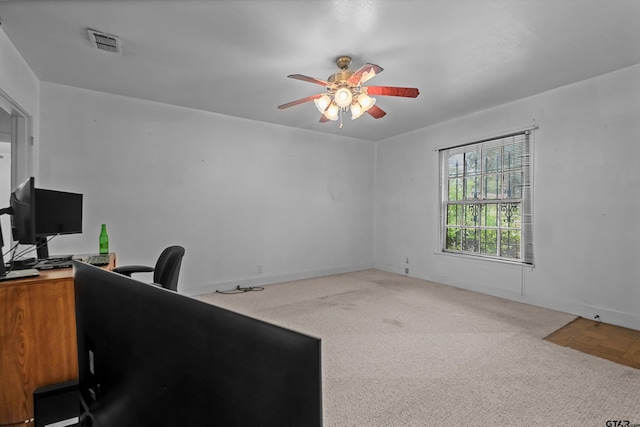 carpeted office with a ceiling fan, visible vents, and baseboards