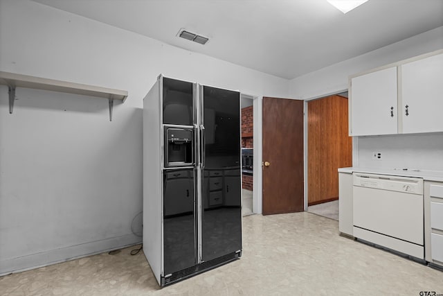 kitchen with light countertops, visible vents, white cabinetry, white dishwasher, and black fridge