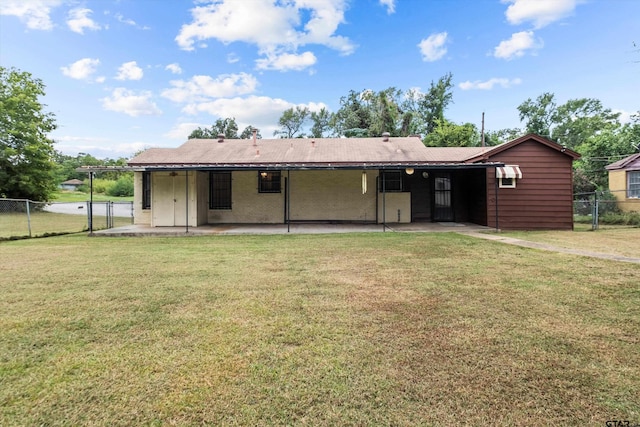 back of property featuring fence, a lawn, and a patio