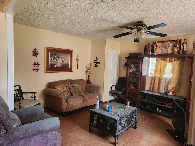 living room with hardwood / wood-style floors, a textured ceiling, and ceiling fan