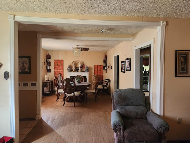 dining space with hardwood / wood-style flooring and a textured ceiling