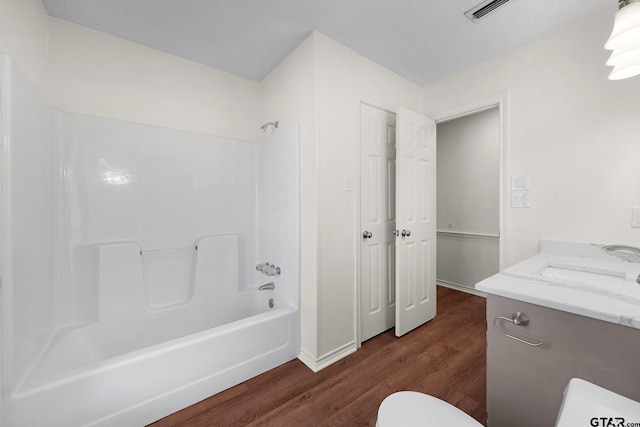 full bathroom featuring vanity, hardwood / wood-style flooring, toilet, and tub / shower combination