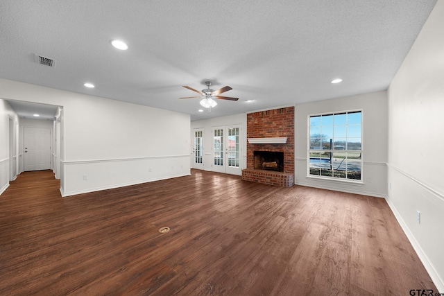 unfurnished living room with ceiling fan, dark hardwood / wood-style flooring, and a textured ceiling