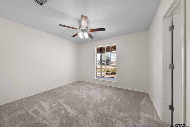 carpeted spare room featuring ceiling fan and a textured ceiling