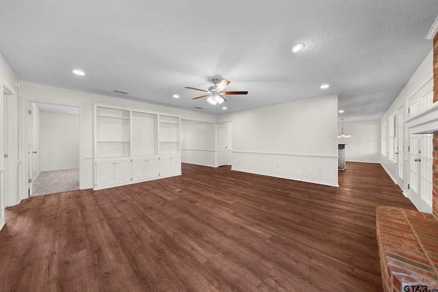 unfurnished living room featuring dark hardwood / wood-style floors, ceiling fan, and a textured ceiling