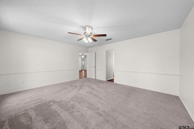 carpeted spare room with ceiling fan and a textured ceiling