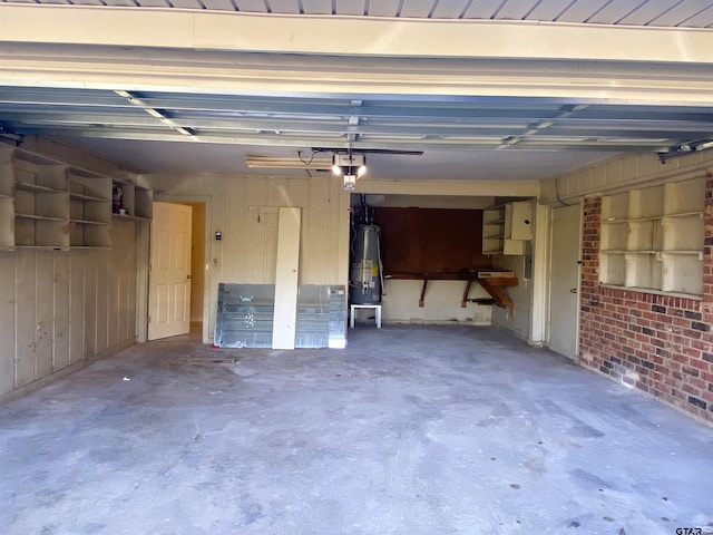 garage with gas water heater, a garage door opener, and wooden walls