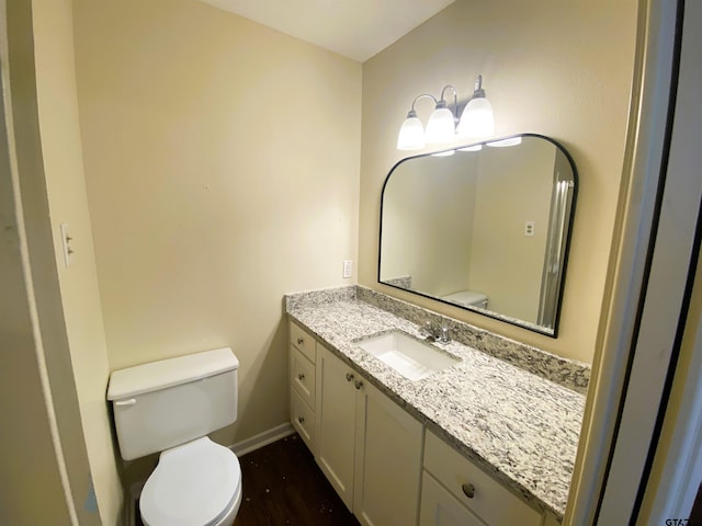 bathroom with toilet, vanity, and hardwood / wood-style flooring