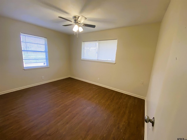 unfurnished room with ceiling fan and dark wood-type flooring