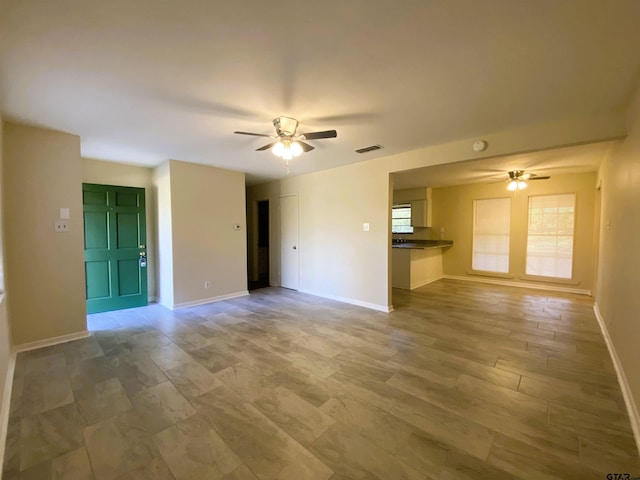 unfurnished living room with ceiling fan