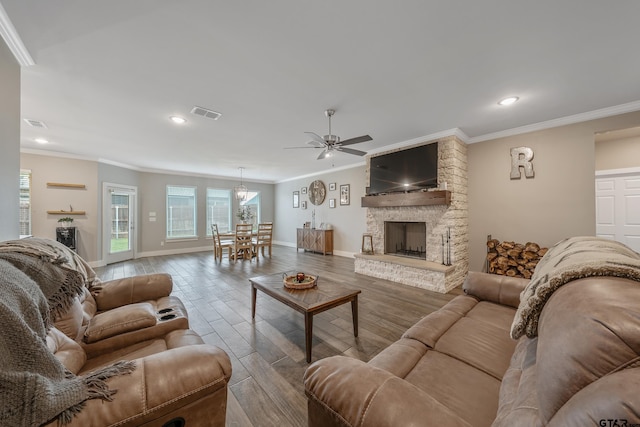 living room with baseboards, visible vents, ornamental molding, wood finished floors, and a fireplace