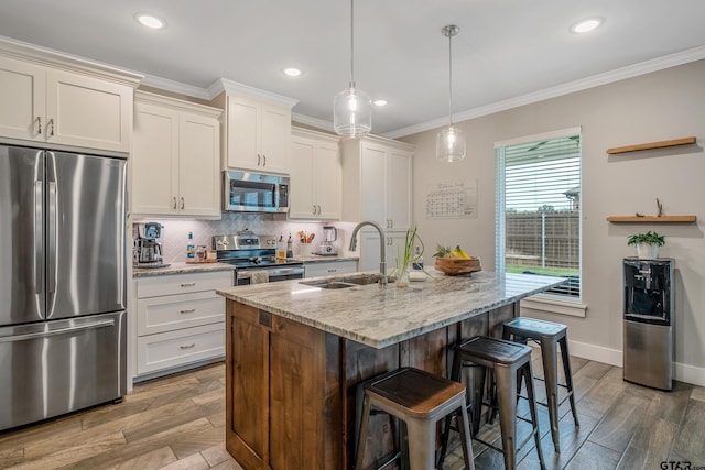 kitchen with stainless steel appliances, a breakfast bar, a sink, tasteful backsplash, and crown molding