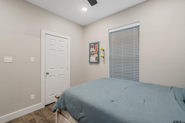 bedroom with a ceiling fan, baseboards, and wood finished floors