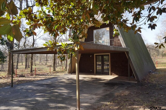 6385 Wagon Tree Trl, Athens, TX 75751 - rear view of house featuring a balcony, driveway, and french doors