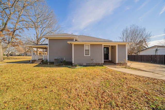 rear view of house with a lawn, central AC unit, and covered porch