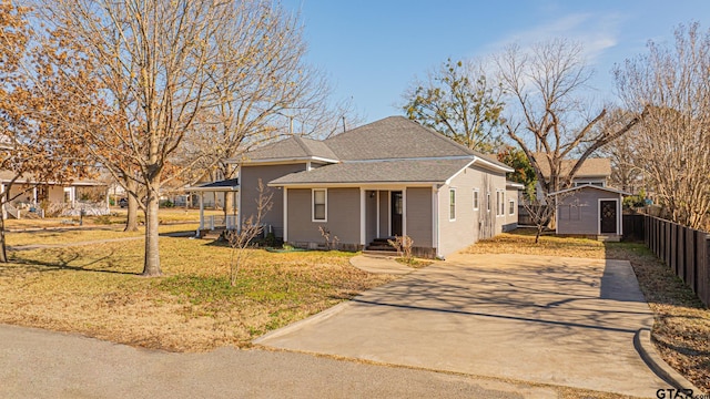 view of front of property with a shed and a front lawn