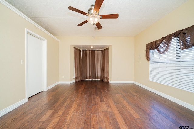 unfurnished room featuring a textured ceiling, ceiling fan, dark hardwood / wood-style flooring, and ornamental molding