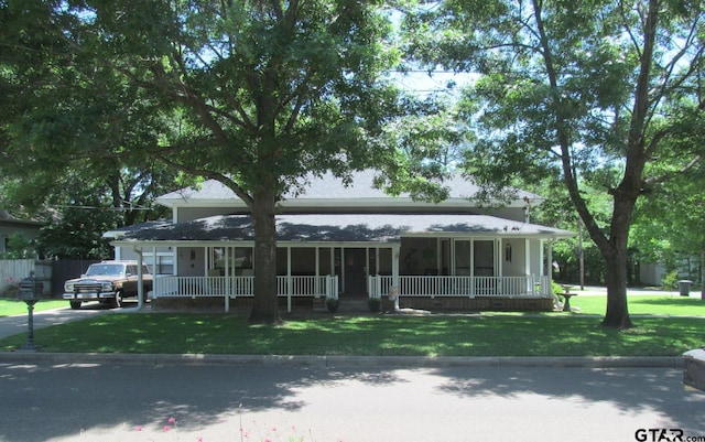 farmhouse with covered porch and a front yard